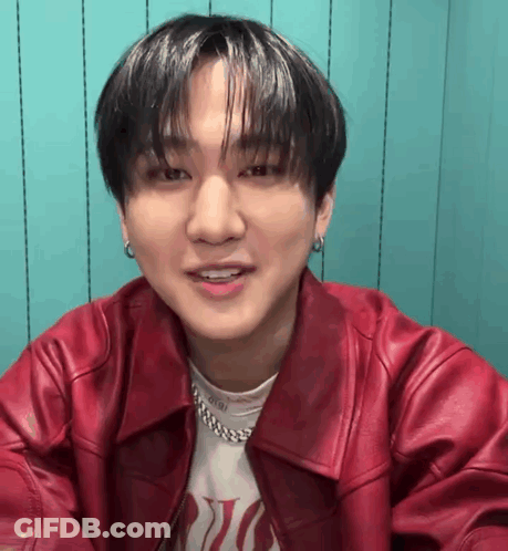 A Close Up Of A Young Man Wearing A Red Leather Jacket And Earrings . GIF
