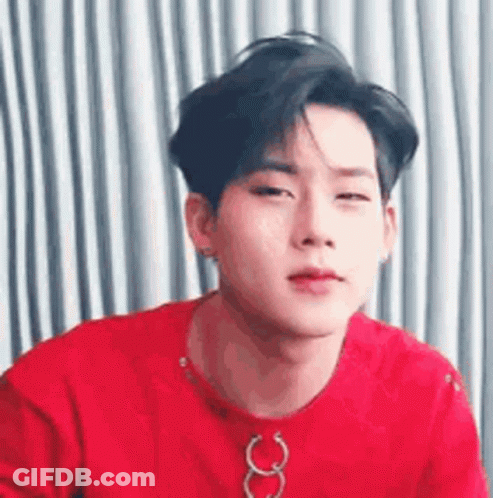 A Close Up Of A Young Man Wearing A Red Shirt And A Necklace . GIF