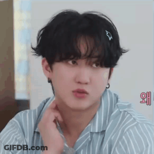 A Close Up Of A Young Man Wearing A Striped Shirt And Earrings . GIF