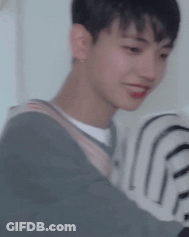 A Close Up Of A Young Man Wearing A Striped Sweater And A White Shirt . GIF