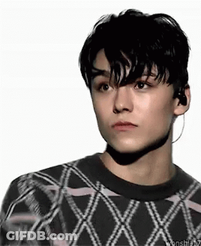A Close Up Of A Young Man Wearing A Sweater And Earbuds . GIF