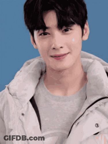 A Close Up Of A Young Man Wearing A White Jacket And A Grey Sweater . GIF