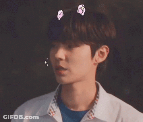 A Close Up Of A Young Man Wearing A White Shirt And A Blue Shirt With Hearts On His Head . GIF