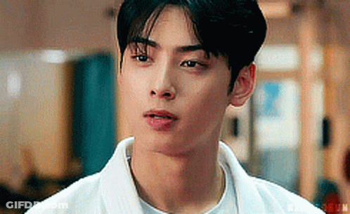 A Close Up Of A Young Man Wearing A White Shirt And A White Jacket . GIF