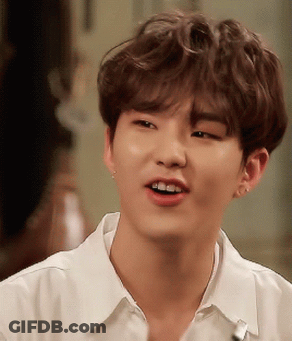 A Close Up Of A Young Man Wearing A White Shirt And Smiling GIF