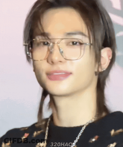 A Close Up Of A Young Man Wearing Glasses And A Necklace GIF