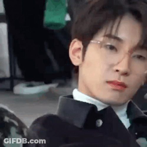 A Close Up Of A Young Man Wearing Glasses And A Suit . GIF