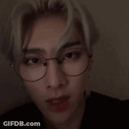 A Close Up Of A Young Man Wearing Glasses And Earrings . GIF