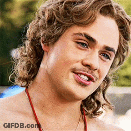 A Close Up Of A Young Man With Curly Hair And A Red Necklace . GIF