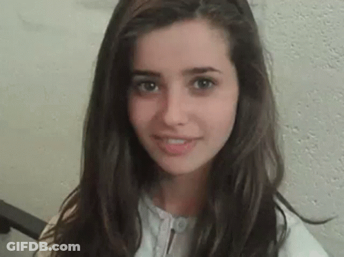 A Close Up Of A Young Woman 'S Face With Long Hair . GIF