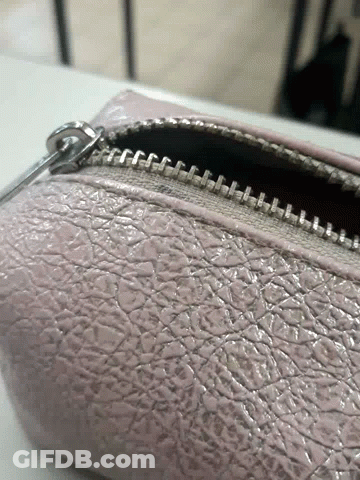 A Close Up Of A Zipper On A Purse GIF