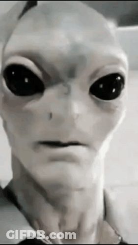 A Close Up Of An Alien With Black Eyes GIF