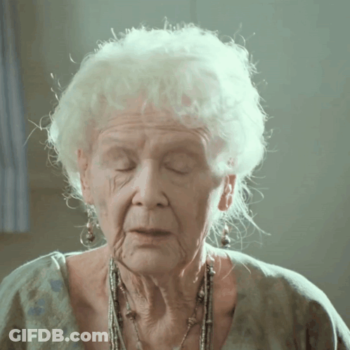 A Close Up Of An Older Woman 'S Face With White Hair GIF