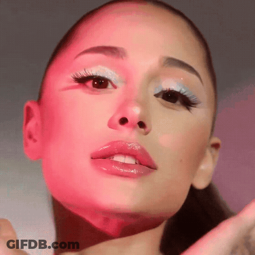 A Close Up Of Ariana Grande 'S Face With Pink And Blue Makeup GIF