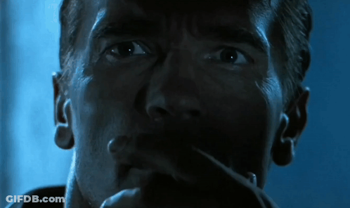A Close Up Of Arnold Schwarzenegger 'S Face In A Dark Room GIF