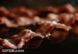 A Close Up Of Bacon Being Cooked In A Pan GIF