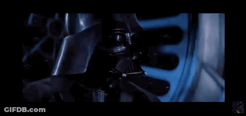 A Close Up Of Darth Vader 'S Face With A Blue Light Coming Out Of His Mouth . GIF