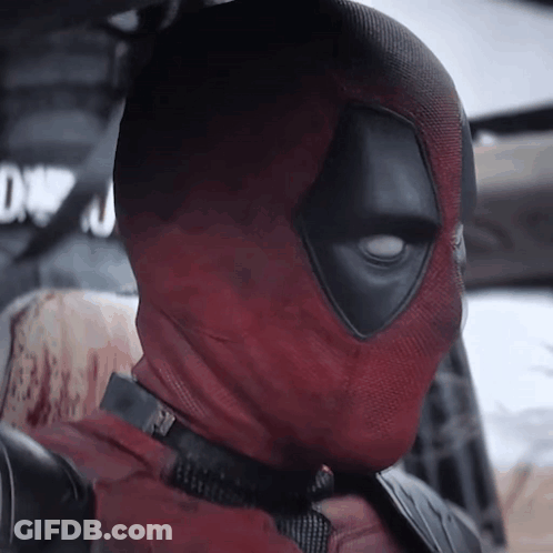 A Close Up Of Deadpool 'S Face With A Sign In The Background That Says Dwn GIF