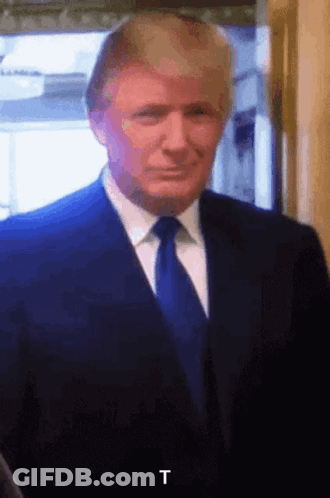 A Close Up Of Donald Trump In A Suit And Tie With The Letter T In The Corner GIF