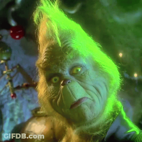 A Close Up Of Grinch 'S Face With Green Hair And Yellow Eyes GIF