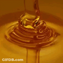 A Close Up Of Honey Pouring Into A Bowl Of Liquid . GIF