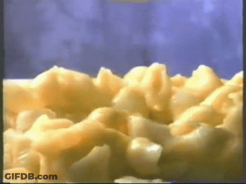 A Close Up Of Macaroni And Cheese Being Cooked In A Microwave . GIF