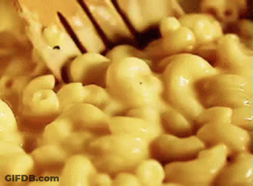 A Close Up Of Macaroni And Cheese Being Stirred With A Fork GIF