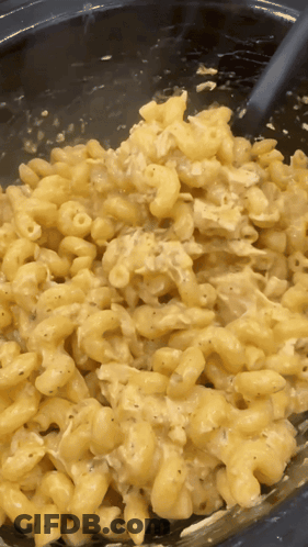 A Close Up Of Macaroni And Cheese With A Spoon In It GIF