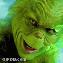 A Close Up Of The Face Of Grinch From The Movie Grinch With A Smile On His Face . GIF
