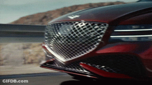 A Close Up Of The Front Of A Red Car With A Checkered Grill GIF