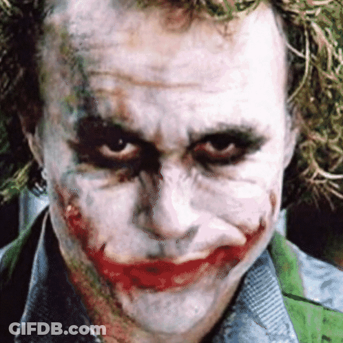A Close Up Of The Joker 'S Face With A Green Shirt GIF