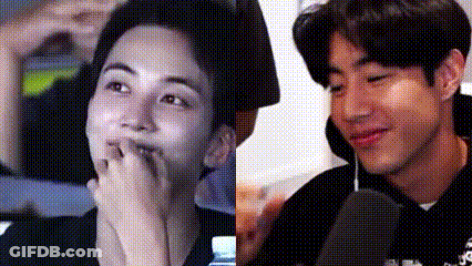 A Close Up Of Two Men 'S Faces , One Covering His Mouth With His Hand . GIF
