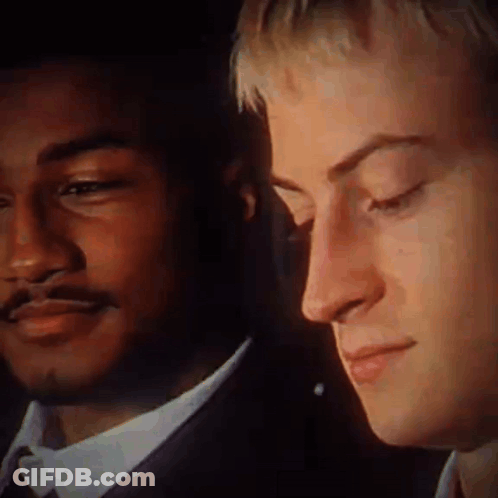 A Close Up Of Two Men 'S Faces With One Wearing A Suit GIF