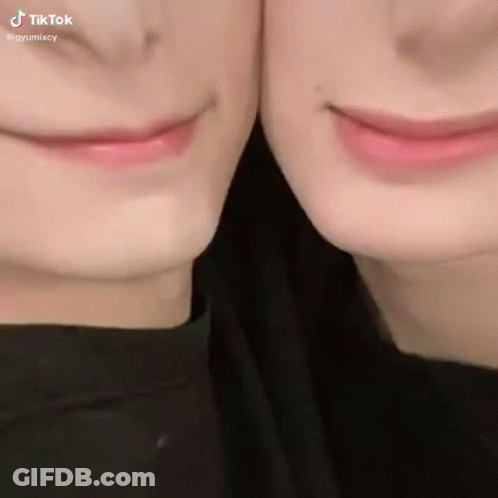 A Close Up Of Two People 'S Faces With Their Mouths Together GIF