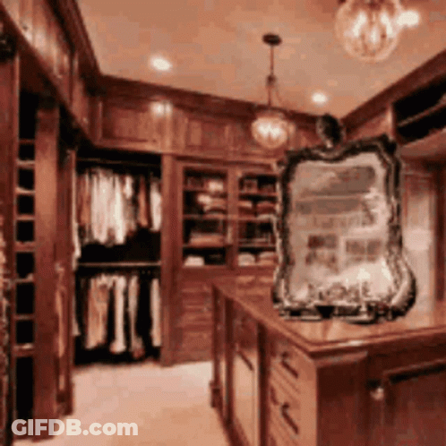 A Closet With Lots Of Clothes And A Mirror In The Middle GIF