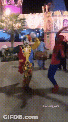 A Clown And A Spiderman Are Dancing In Front Of A Castle GIF