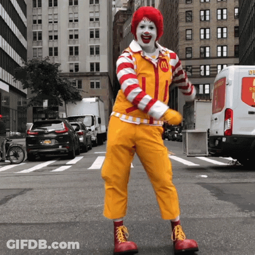 A Clown In A Mcdonald 'S Costume Is Dancing On The Street GIF