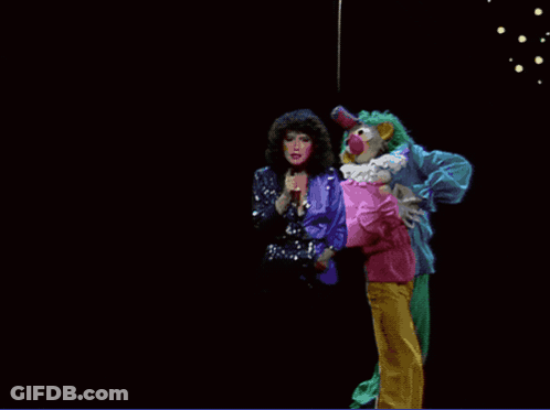 A Clown Is Holding A Woman In A Pink Shirt GIF