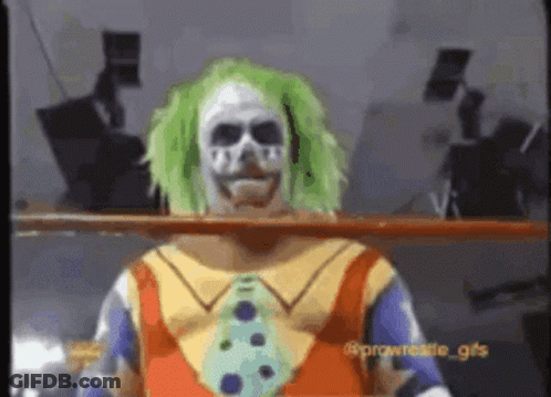 A Clown With Green Hair And A Skull Mask Is Standing In A Wrestling Ring . GIF