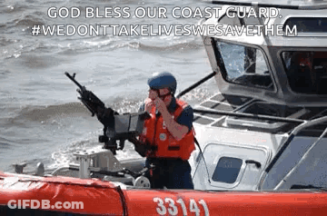 A Coast Guard Officer Is Standing On A Boat In The Water Holding A Gun . GIF