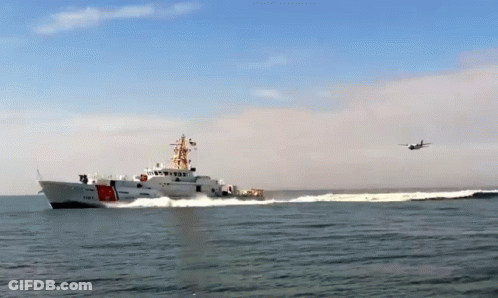 A Coast Guard Ship With A Plane Flying Overhead GIF