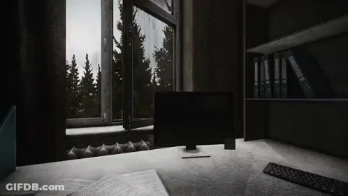 A Computer Is Sitting On A Desk In Front Of A Window In A Dark Room . GIF