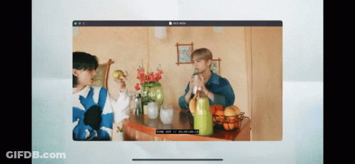 A Computer Screen Shows Two People Sitting At A Table Drinking From Bottles . GIF