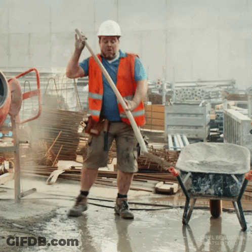 A Construction Worker Is Standing In A Puddle Holding A Stick GIF