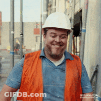 A Construction Worker Wearing An Orange Vest And A White Hard Hat GIF