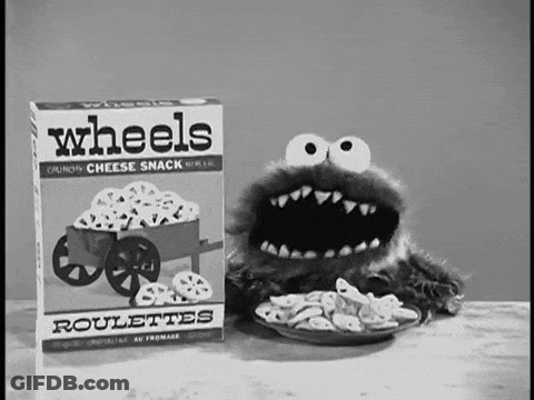 A Cookie Monster Is Eating Wheels Roulettes From A Box . GIF