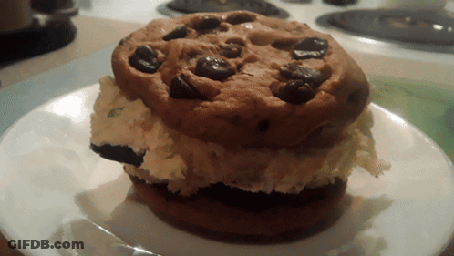 A Cookie With Chocolate Chips On Top Of A White Plate GIF