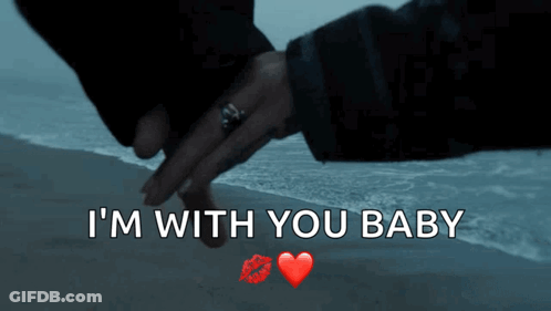A Couple Holding Hands On A Beach With The Words I 'M With You Baby GIF