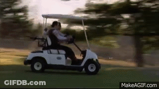 A Couple Is Riding A Golf Cart On A Golf Course . GIF