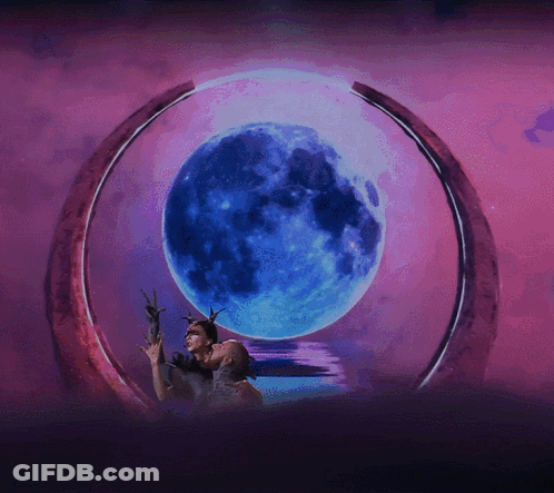 A Couple Kissing In Front Of A Blue Moon GIF